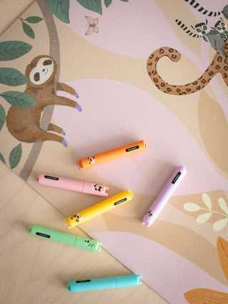 Schreibtischunterlage mit pinkem Jungle Animals-Motiv, abwaschbar, Tier-Illustrationen; bunte Stifte mit Tiermotiven darauf.