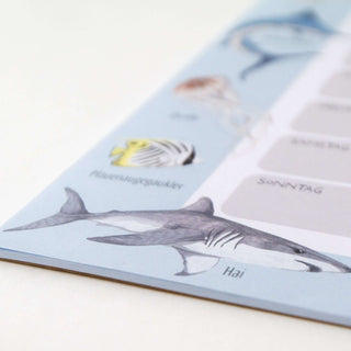 Schreibtischunterlage mit Wochenplaner-Design, illustrierten Meerestieren wie Hai und bunten Fischen, ideal für Schulstart.