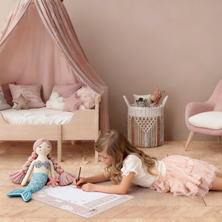 Mädchen malt auf Schreibtischunterlage Meerjungfrau Einhorn am Boden spielend Kinderzimmer