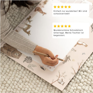 Das Bild zeigt einen Ausschnitt von der Schreibtischunterlage für Kinder, als Papierblock, mit Waldtiere und Kundenbewertungen.