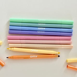 OMY Pastell Filzstifte Set, 9 Stifte in sanften Farbtönen aufgereiht, offen mit abgenommenen Kappen. Sichtbare Doppelspitze. Zum Malen von Details und größeren Flächen.