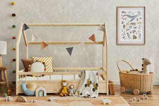 Kinderzimmerausschnitt mit Holzbett, Spielsachen und ABC Kinderposter an der Wand.