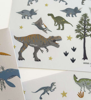 Dinosaurier-Sticker-Set mit T-Rex, Triceratops, Pterodactylus und Brontosaurus. Enthält Dino-Fußabdrücke, Bäume und Sterne.