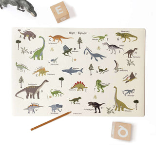 Kinderschreibtischunterlage mit Dino ABC. Bei jedem Buchstaben gibt es einen passenden handgezeichneten Dinosaurier. Die Hintergrundfarbe ist ein kühles beige. Die Dinos sind bunt in dezenten Farbtönen gemalt. Es sind als Dekoration noch ein Dino, Bleistift und zwei ABC Würfel beigelegt.