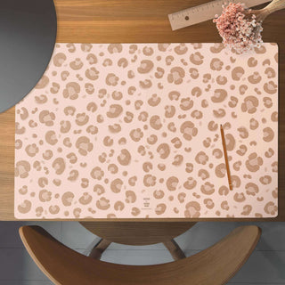 Leopardenmuster-Schreibtischunterlage, abwaschbar, auf Holzschreibtisch, mit Stift, Lineal und Blumenarrangement daneben.