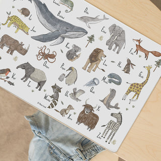 Kinder-Schreibtischunterlage zeigt waschbares Tier-ABC auf Holzunterlage mit illustrierten Tieren von A bis Z, darunter ein Wal.