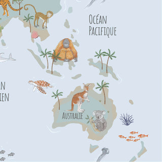 Illustrierte Schreibtischunterlage mit Weltkarte, auf der verschiedene Tiere wie Kängurus, Koalas und Affen abgebildet sind; Beschriftung auf Französisch.